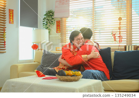 Elderly father hugs his adult son with warmth and gratitude during a heartfelt Chinese New Year family reunion Elderly father hugs his adult son with warmth and gratitude during a heartfelt Chinese New Year family reunion 135249034