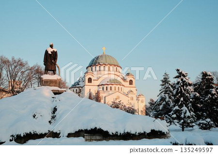 Orthodox St Sava church in Belgrade and historic monument stand covered with snow under clear winter sky. The scene reflects cultural heritage, faith, and winter atmosphere in the city Orthodox St Sava church in Belgrade and historic monument stand covered with snow under clear winter sky. The scene reflects cultural heritage, faith, and winter atmosphere in the city 135249597