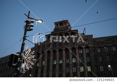 Historic post office building with monumental stone facade under winter evening sky. Urban architecture expressing stability, communication, and classic city heritage 135249603