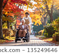 護理人員和患者在柔和的秋日陽光下，沿著鋪滿秋葉的街道悠閒漫步。 135249646
