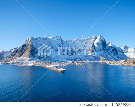 High arctic mountains and steep cliffs rising above deep fjord in winter, Norway High arctic mountains and steep cliffs rising above deep fjord in winter, Norway 135249822