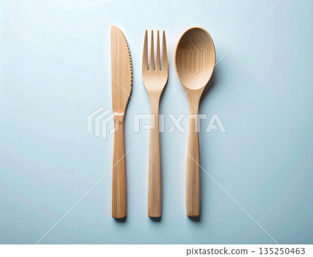Sustainable lifestyle. Set of eco-friendly bamboo cutlery: wooden spoon, fork and knife on a white background. 135250463