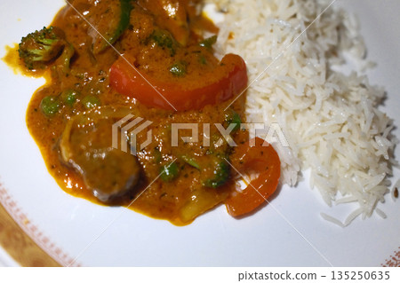 Traditional Indian meals with colorful spices, rice, curry and flatbread served on decorated table. 135250635