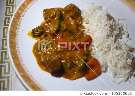 Traditional Indian meals with colorful spices, rice, curry and flatbread served on decorated table. Traditional Indian meals with colorful spices, rice, curry and flatbread served on decorated table. 135250636