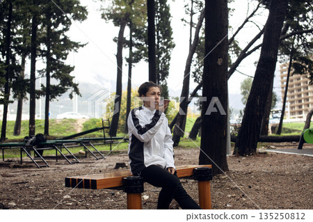 young pretty brunette woman outside making sport exercises on training playground, lifestyle people concept 135250812