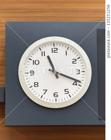 Wall clock showing time in public terminal interior. Time, schedule, and coordination in structured travel and daily environments. Wall clock showing time in public terminal interior. Time, schedule, and coordination in structured travel and daily environments. 135251256