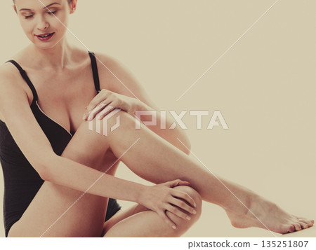 Sitting woman in underwear showing smooth legs Sitting woman in underwear showing smooth legs 135251807