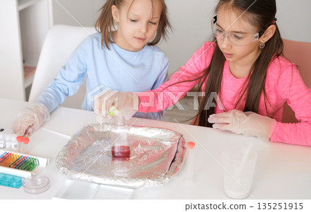 Children jointly conduct experiments with liquids and chemicals in the classroom at school 135251915