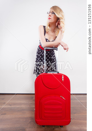 woman pulling heavy red travel bag woman pulling heavy red travel bag 135251936