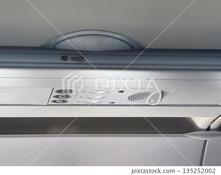 Airplane overhead compartments and ceiling. Aviation design, passenger service, and storage inside cabin. 135252002