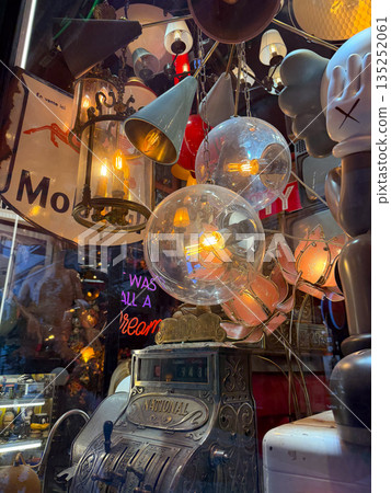 Vintage lamps and chandeliers with warm glowing bulbs. Retro design, nostalgia, and cozy ambiance. 135252061