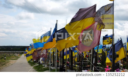 View on blue-yellow flags at countless graves of ukrainian soldiers alley of glory in Kharkiv. This site commemorates heroes and maintains the memory of wartime events in Ukraine. Slow moiton View on blue-yellow flags at countless graves of ukrainian soldiers alley of glory in Kharkiv. This site commemorates heroes and maintains the memory of wartime events in Ukraine. Slow moiton 135252212