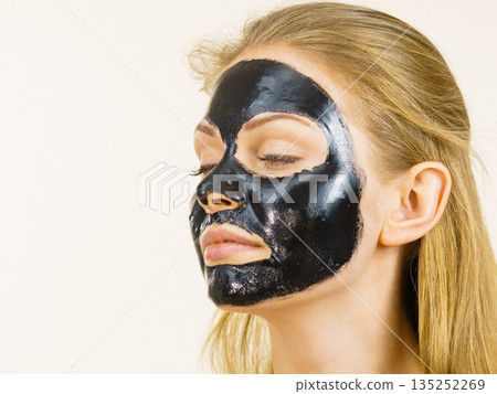 Girl black carbo peel off mask on face Girl black carbo peel off mask on face 135252269