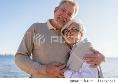 Senior mature couple hugging enjoying outdoor recreation walking on beach. Old husband wife embracing with tenderness love enjoying sweet bonding. Grandmother grandfather together. Family moment love 135252281