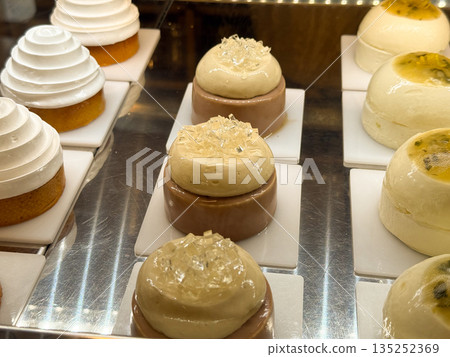 Mousse desserts with clear jelly topping on a patisserie counter. Elegant confectionery, layered texture, and premium sweet design Mousse desserts with clear jelly topping on a patisserie counter. Elegant confectionery, layered texture, and premium sweet design 135252369