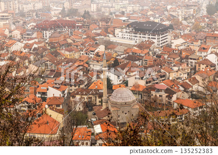 Urban panorama with mosque dome, minaret and residential buildings forming a dense city center under overcast daylight conditions, Prizren, Kosovo Urban panorama with mosque dome, minaret and residential buildings forming a dense city center under overcast daylight conditions, Prizren, Kosovo 135252383