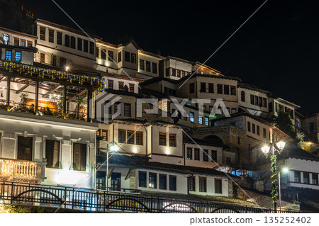 Night view of historic Albanian town with traditional Ottoman houses on a hillside with white stone architecture illuminated by street lights, Berat, Albania Night view of historic Albanian town with traditional Ottoman houses on a hillside with white stone architecture illuminated by street lights, Berat, Albania 135252402