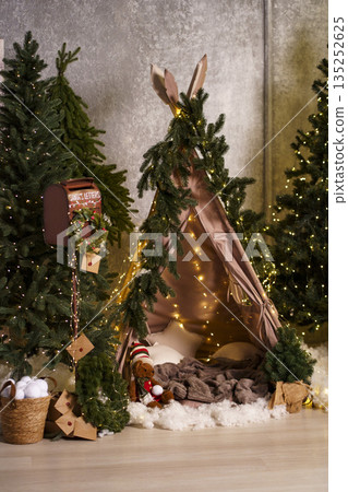Cozy children's Christmas teepee with fairy lights, wooden sled and holiday decor Cozy children's Christmas teepee with fairy lights, wooden sled and holiday decor 135252625