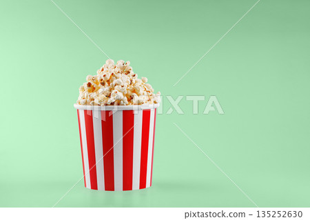 Classic red striped popcorn cardboard cup on Green background 135252630