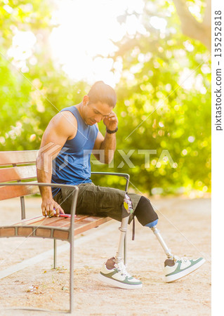 Disabled Middle-aged man athlete resting after training with prosthetic legs 135252818
