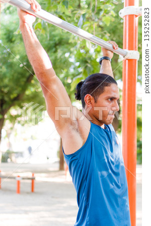 Venezuelan athlete training calisthenics in outdoor park 135252823