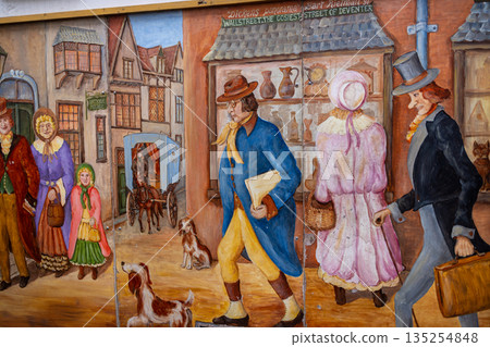 Deventer, Overijssel, Netherlands - 14.12.2025: At the Charles Dickens Festival. Colorful mural depicts Victorian street life with carriages, costumes, dogs, and shopfronts. Deventer, Overijssel, Netherlands - 14.12.2025: At the Charles Dickens Festival. Colorful mural depicts Victorian street life with carriages, costumes, dogs, and shopfronts. 135254848