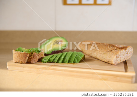 Avocado Toast With Slices And Half Avocado On Wooden Cutting Board 135255181