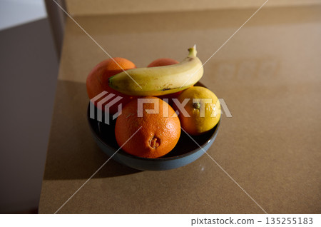 Fruit Bowl With Bananas Oranges And A Lemon In A Blue Bowl On Kitchen Counter 135255183