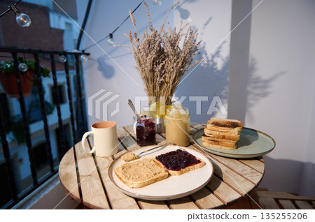 Cozy Balcony Breakfast With Toast, Jam, Peanut Butter And Dried Wheat Vase Cozy Balcony Breakfast With Toast, Jam, Peanut Butter And Dried Wheat Vase 135255206