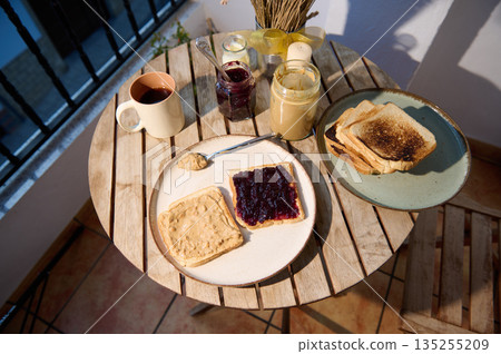 Cozy Balcony Breakfast With Toast, Jam, Peanut Butter, And Coffee 135255209