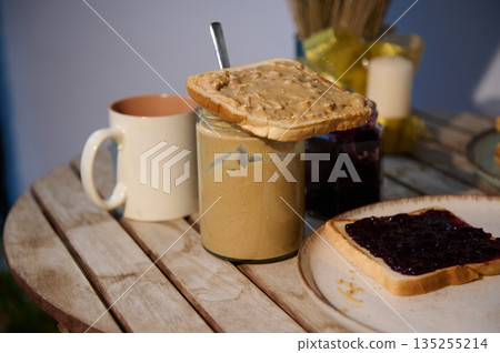 Toast With Peanut Butter On Jam Jar Morning Breakfast Scene On Wooden Table Toast With Peanut Butter On Jam Jar Morning Breakfast Scene On Wooden Table 135255214