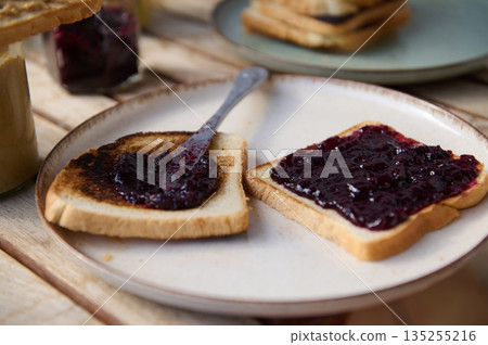 Toast With Berry Jam on Plate: Simple Breakfast Spread With Rustic Table Setting Toast With Berry Jam on Plate: Simple Breakfast Spread With Rustic Table Setting 135255216