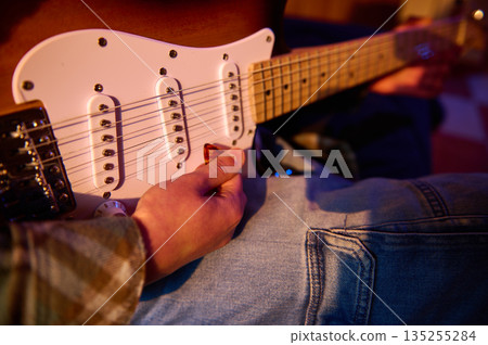 Close-Up Of A Person Playing An Electric Guitar With A White Stratocaster 135255284