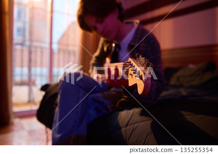 Cozy Room Guitarist Relaxing on Bed With Soft Lighting and Warm Evening Mood Cozy Room Guitarist Relaxing on Bed With Soft Lighting and Warm Evening Mood 135255354