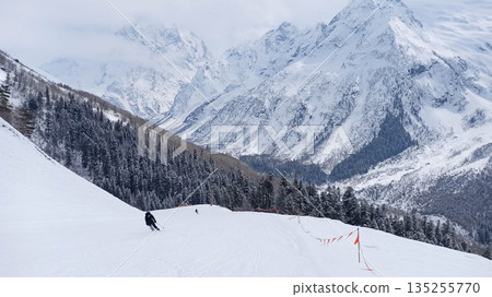 Skier descending a snowy slope at Dombay resort Skier descending a snowy slope at Dombay resort 135255770