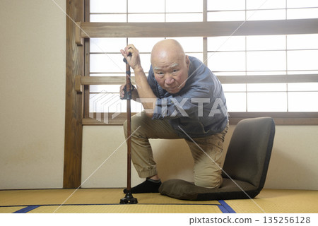 An elderly man doing rehabilitation indoors using a cane An elderly man doing rehabilitation indoors using a cane 135256128