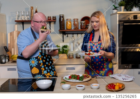 Two persons enthusiastically critique recently developed culinary creation, Pair of evaluators apply intense emotional reactions to pioneering new food experience 135256265