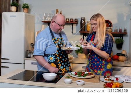 Cooking duo collaborating, Friends preparing meal together, Two individuals discussing ingredients in kitchen, Pair of cooks organizing supplies and sharing ideas 135256266