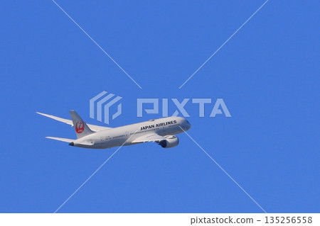 一架飛機在轉彎時爬升。一架日航飛機傾斜並轉彎。 135256558