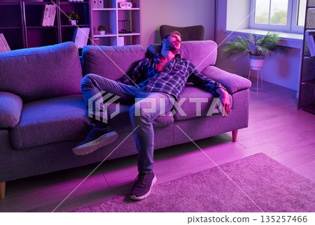 Man with drugs dependence and addiction lying on home sofa after nightclub party Man with drugs dependence and addiction lying on home sofa after nightclub party 135257466