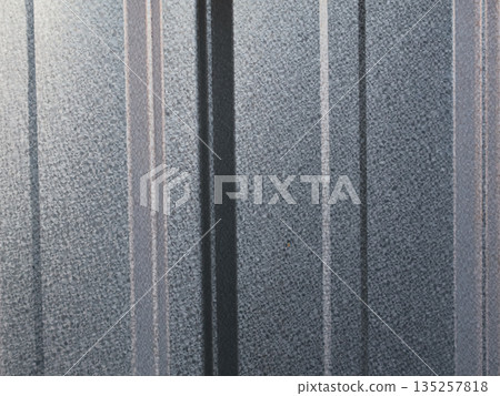Textured metal siding panels reflecting natural light with copy space for industrial design mockups and abstract architectural background usage Textured metal siding panels reflecting natural light with copy space for industrial design mockups and abstract architectural background usage 135257818