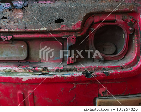 Rusty Red Car Detail with Extensive Corrosion and Natural Light showing Weathered Texture and Industrial Decay for Automotive Theme 135257820