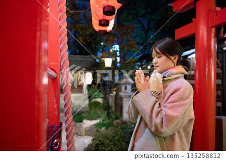 一位戴著圍巾的女子在新年第一次參拜神社時虔誠地許願。 135258812