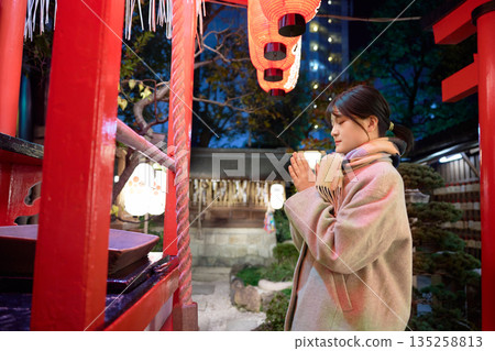 年輕女子在夜間於神龕前祈禱。 135258813