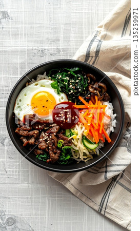 Studio Food Photography of Korean Bibimbap in Black Ceramic Bowl 135259971