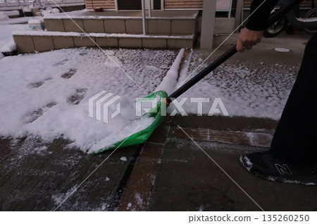 Hands shoveling snow, a winter morning scene Hands shoveling snow, a winter morning scene 135260250