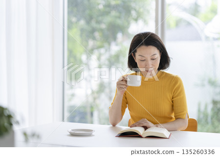 一位五十多歲的女士正在讀書 135260336