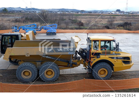 一輛鉸接式自卸卡車停在河邊的建築工地 一輛鉸接式自卸卡車停在河邊的建築工地 135261614