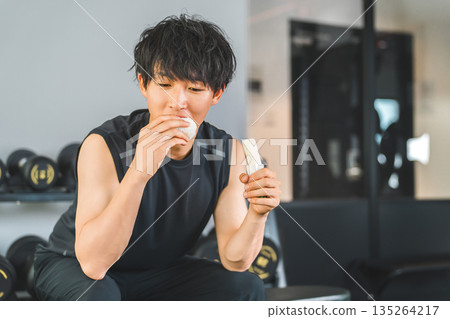 Young Asian man doing muscle training refueling before and after training 135264217