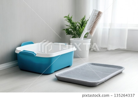 Litter Box with shovel. Clumping cat in home background. Clean blue white cat litter box with scoop on wooden floor in a minimalist room. Cleanliness and hygiene concept. Cat toilet. Hygiene for pets 135264337
